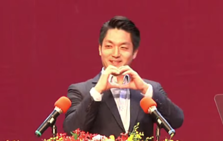 台北市長蔣萬安4日世新大學畢業典禮,雙手比愛心向世新畢業生送上祝福。(直播截圖)