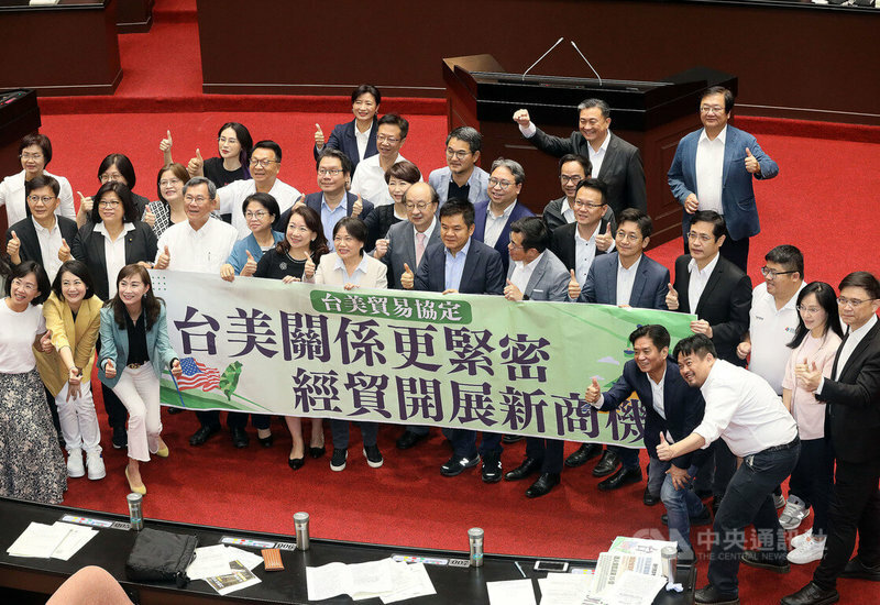 立法院臨時會院會7月26日曾無異議通過「台美21世紀貿易倡議」首批協定,眾立委在議場內持標語合影。(中央社)