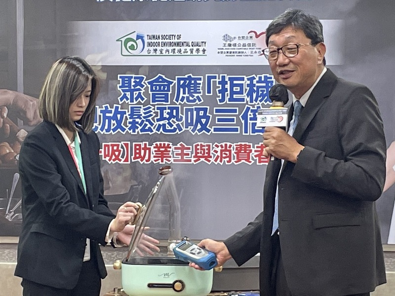 長榮大學職業安全與衛生學系副教授張振平(右)22 日於記者會現場檢測燒烤油煙的空氣品質。(Photo by 簡嘉佑/台灣醒報)
