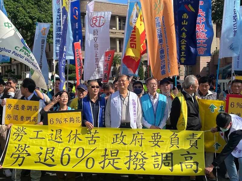 眾多工會代表高舉旗幟,15日齊聚於行政院門口高呼口號,要求政府提高勞退提撥率,提供勞工老年生活保障。(Photo by 簡嘉佑/台灣醒報)