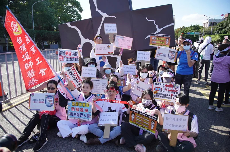 台灣醫事人員大聯盟19日在凱達格蘭大道發起「黑十 字運動」,舉起標語表達訴求,盼政府重視醫護工作。(中央社)