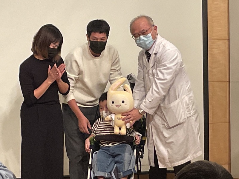 臺大醫院院長吳明賢(右)贈送吉祥物給接受視覺復能計畫的家屬。(Photo by 簡嘉佑/台灣醒報)