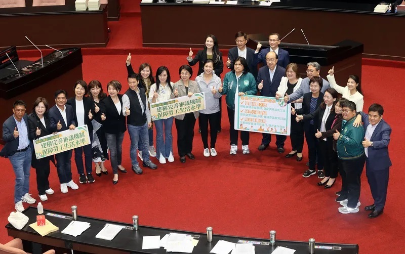 最低工資法立法院三讀通過,民進黨立院黨團在議場內拍照記錄。(中央社)