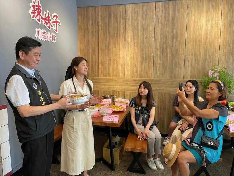 海基會與陸委會、移民署26日赴金門關懷陸配家庭並舉辦「一人一菜」活動。圖為海基會法律處長張峯青(左一)介紹陸配的一人一菜。(海基會提供)