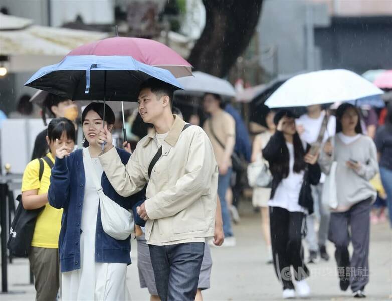 圖為台北華山1914文化創意產業園區,民眾撐傘遮雨。(中央社)