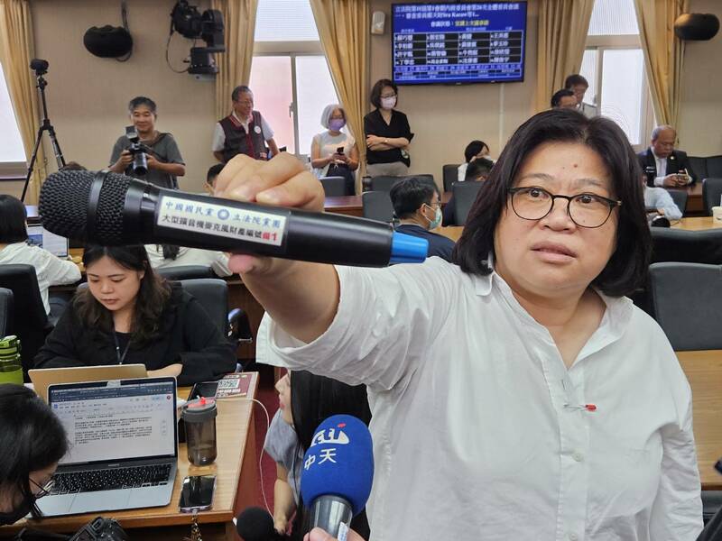 民進黨立委王美惠撿到國民黨立院黨團的麥克風。(Photo by 呂翔禾/台灣醒報)
