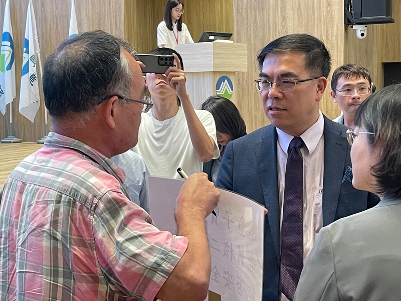 環境部長彭啟明(中)31日出席高溫適應對策研討會,有民眾上前探討核能議題。(Photo by 簡嘉佑/台灣醒報)