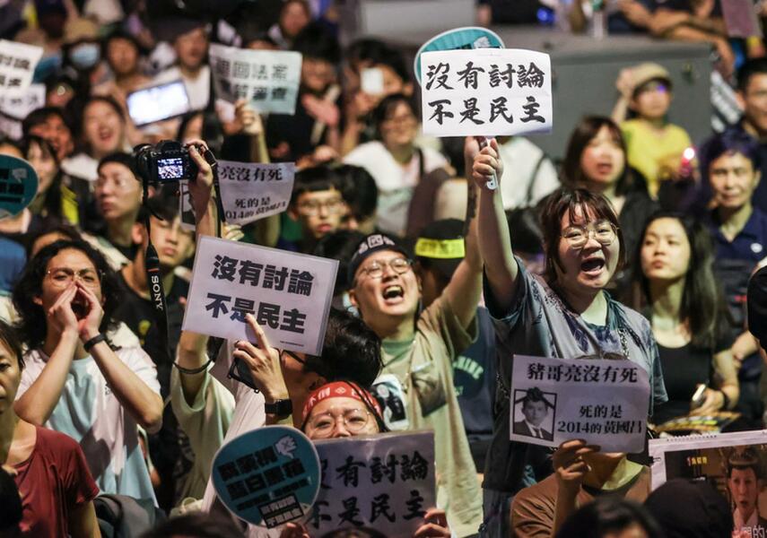 青島東路上民眾手持寫有「沒有討論 不是民主」的標語表達立場。(中央社)